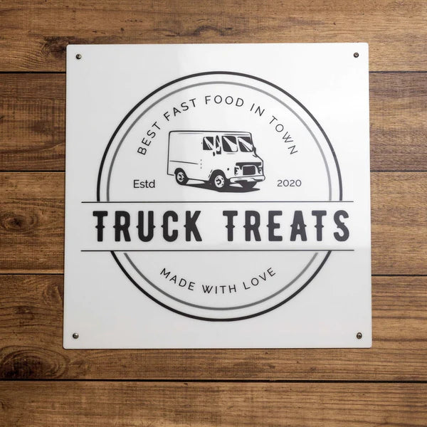 Mounted metal sign shows food truck graphic with “TRUCK TREATS” and text: “BEST FAST FOOD IN TOWN” and “MADE WITH LOVE.”