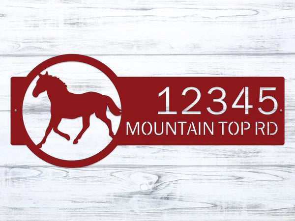 Close up Deep red metal address sign with a  horse silhouette on the right and the custom address '12345 Mountain Top Rd' in bold, rustic lettering for outdoor use.