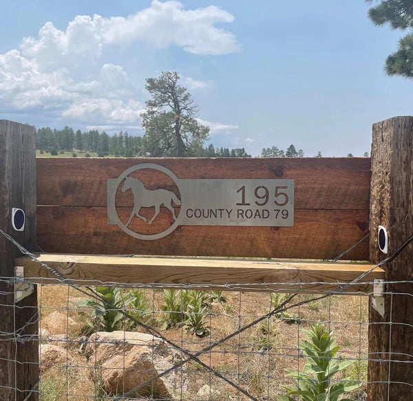 Polished chrome address sign with horse silhouette on right and '195 Country Road 79' on left in bold, rustic outdoor design.