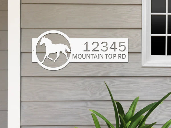 White metal address sign with a  horse silhouette on the right and the custom address '12345 Mountain Top Rd' on the left, featuring bold, clear lettering and a rustic design for outdoor use.