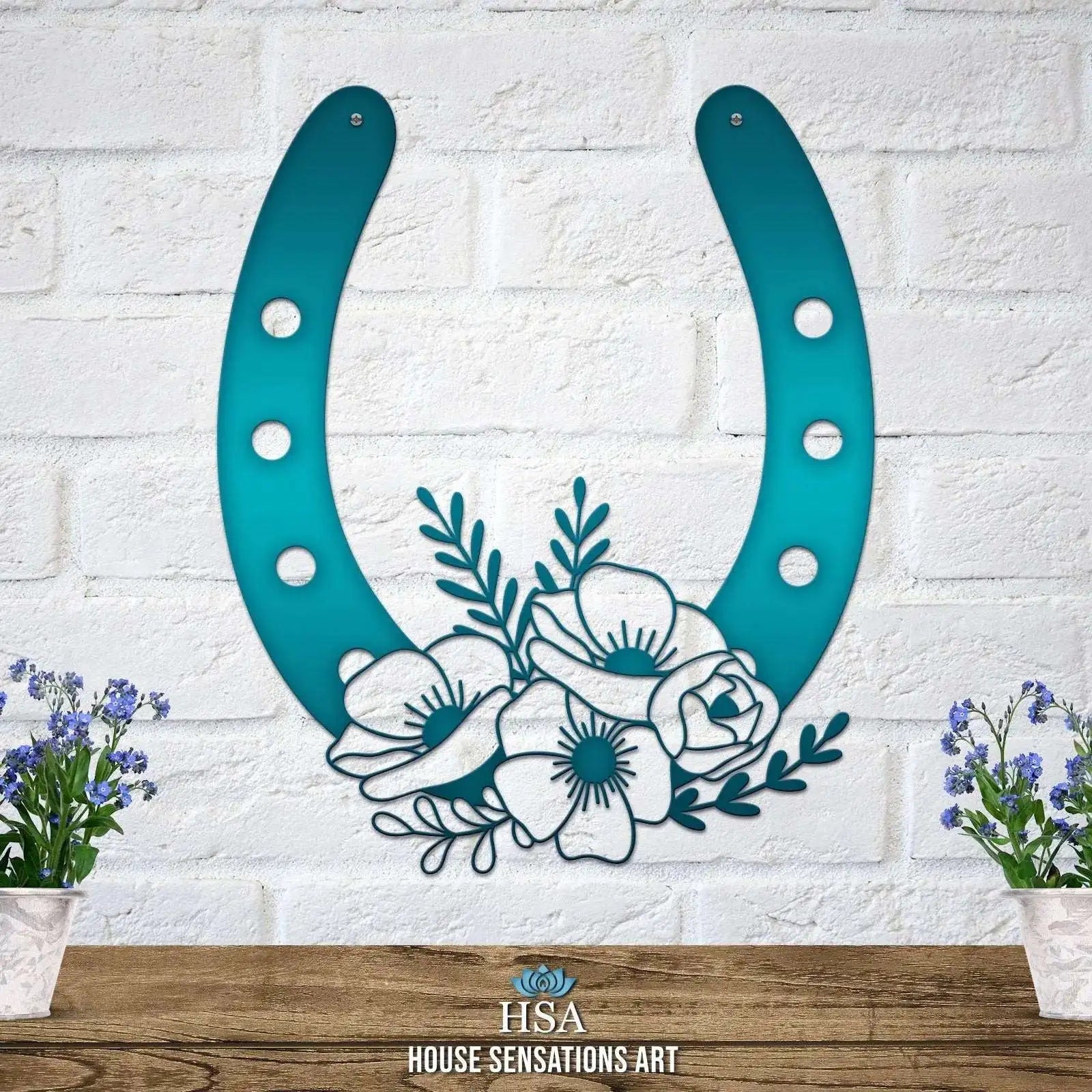 Decorative metal horseshoe wall art with floral design on white brick wall, lucky home décor, blue green finish, House Sensations Art brand sign