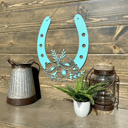 Turquoise metal horseshoe wall art with lanterns and plant on wood surface, lucky farmhouse décor, decorative home gift sign