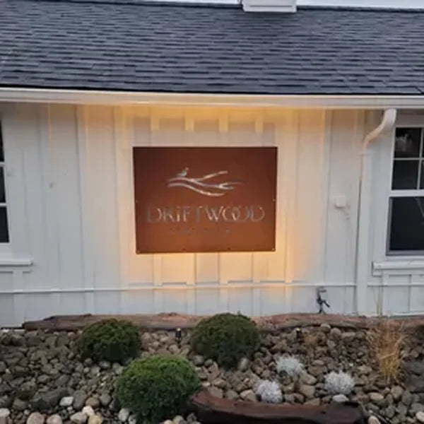 Custom metal business sign installed at a building entrance