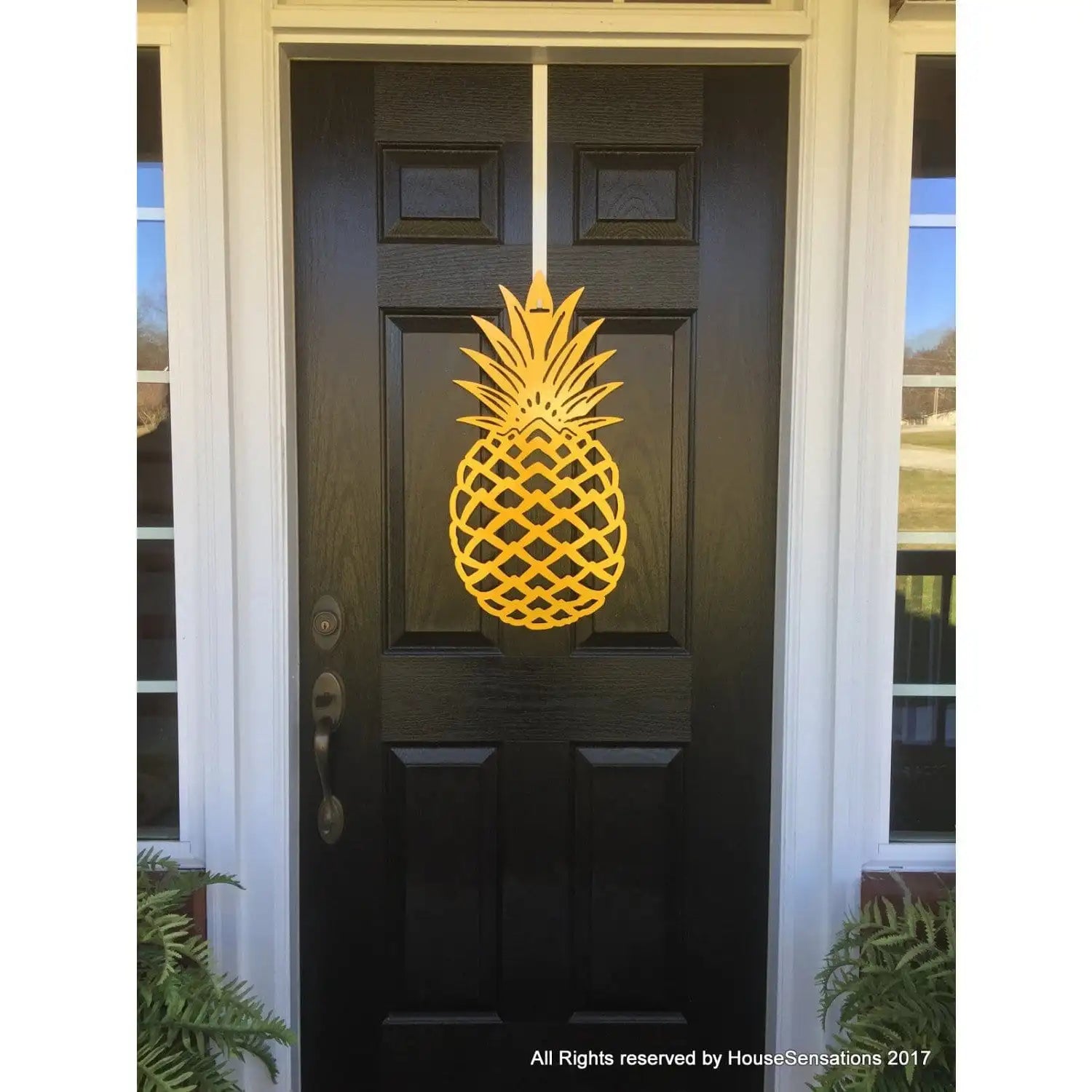 Pineapple Front Door Wreath - Customizable Metal Door Decor displayed on a black door, featuring a laser-cut yellow pineapple design symbolizing hospitality. Perfect for home, porch, or garden; durable and rust-resistant.