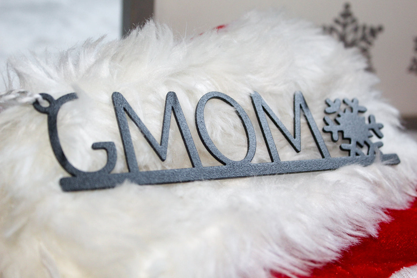 Christmas Stocking Name Tags Metal With Snowflake - Custom made; black laser-cut name tag displayed on a fluffy white surface, showcasing intricate snowflake design, perfect for festive decoration personalization.