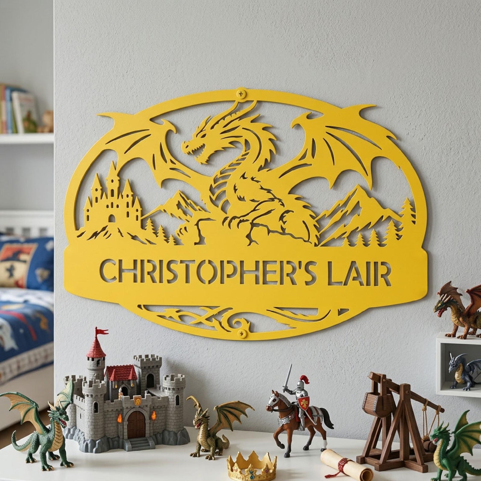 An oval dragon sign with large dragon silhouette, castle, & mountains that reads "CHRISTOPHER'S LAIR". Sign is finished in Spring Yellow and is shown displayed as bedroom wall art in dragon kids room above dragon figurines