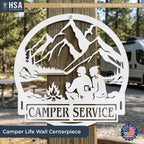 Custom camper sign: round metal trailer name plate with mountains, trees, campfire and two campers for outdoor lake decor.