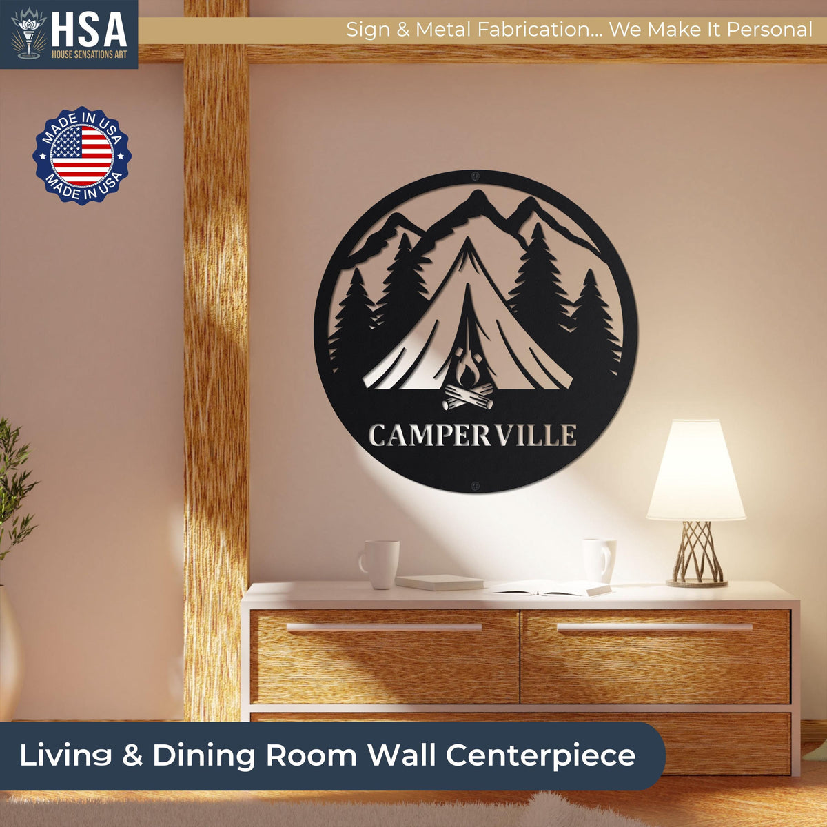 Round black metal camper sign with mountain and pine silhouette reading CAMPER VILLE, camping wall decor above a dresser.