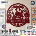Introducing the Personalized Teacher Name Classroom Sign - a round custom metal sign shown in Deep Red displayed on a classroom wall. Features a beautiful collage of schoolbooks, teacher's apple, ruler, pencil in coffee mug, and ornate bow & flower, with personalized name plaque across the lower half. Featured photo reads Mrs. Taylor. Sign comes with color-matching screws and is available in more than 50 color finishes