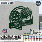 Introducing HouseSensationsArt 's Pickleball Paddle Custom Metal Sign. A unique & creative sign featuring a pickleball paddle and pickleball ball graphic with horizontal name plaque for personalization. Pictured sign is shown in Bionic Green & reads MIKE & PATTY, Pickleball Champions 2026. Available in more than 50 colors, and included color matching screws for easy mounting. Ships in 48 hours when ordered before noon.