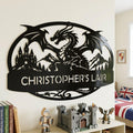 Personalized Dragon Name Plaque: Custom Bold Line Dragons Playhouse Door Sign & Kids Room Decor - An oval shaped custom metal sign featuring a mythical dragon with wings spread, with medieval castle and scenic mountain background. Features personalized name. and is shown in Gloss Black in dragon themed kids bedroom. above castle lego set.