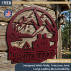 Custom round burgundy metal camper sign showing mountains, a campfire couple, with CAMPER SERVICE, RV outdoor decor.