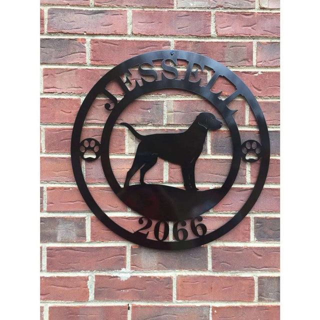 A black metal wall sign showing a Labrador dog silhouette standing, with “JESSELL,” “2066,” and paw prints on each side.