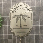 Custom metal office and storefront sign with laser-cut “Cleary Lane” logo and palm tree design, decorative steel wall art on tiled background.