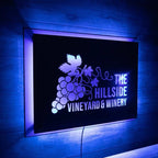 LED metal sign for “The Hillside Vineyard & Winery” featuring a grape design, displayed on a dark background with backlit illumination, highlighting vibrant colors and elegant branding.