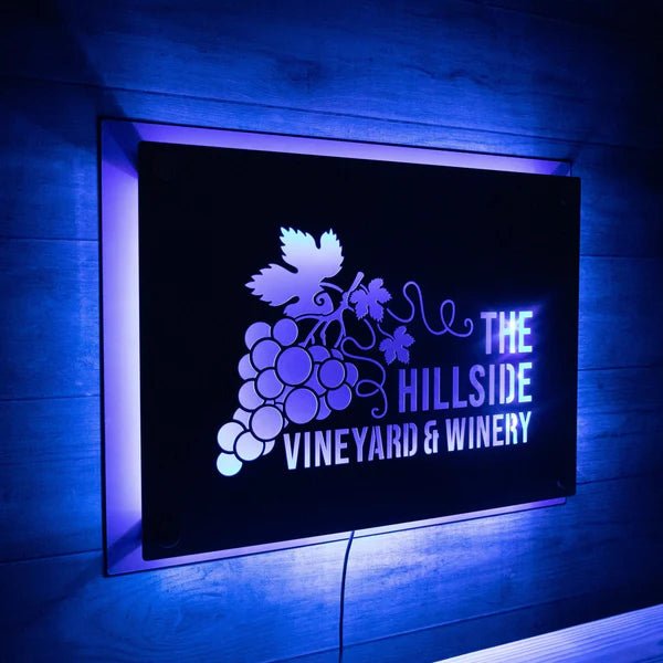 LED metal sign for “The Hillside Vineyard & Winery” featuring a grape design, displayed on a dark background with backlit illumination, highlighting vibrant colors and elegant branding.