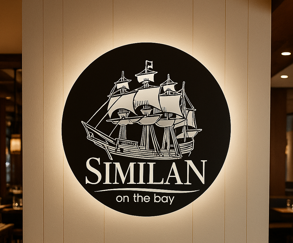 Metal business logo sign mounted on a wall with LED backlighting for visibility and style.