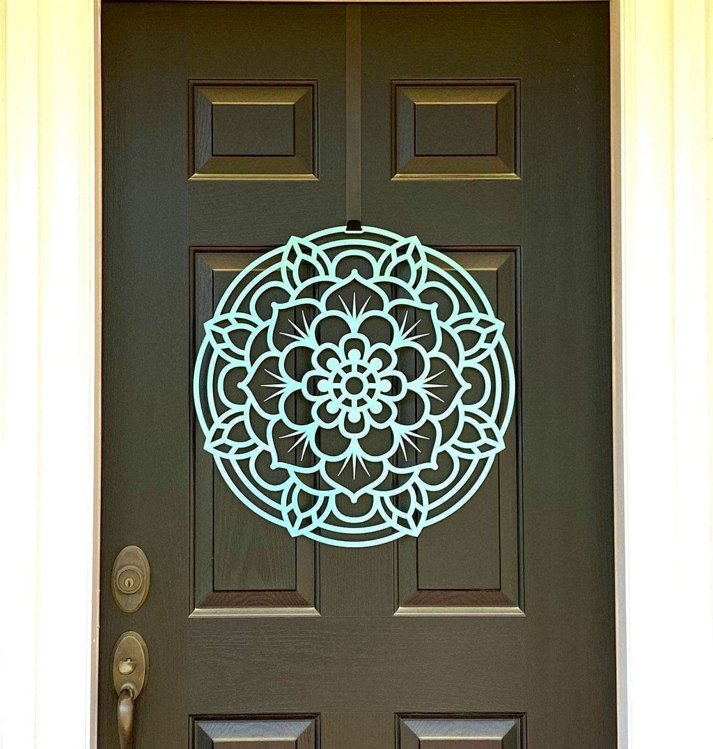 Decorative mandala wall art displayed on a dark green front door, featuring an intricate lotus-inspired design and durable metal craftsmanship for stylish outdoor décor.