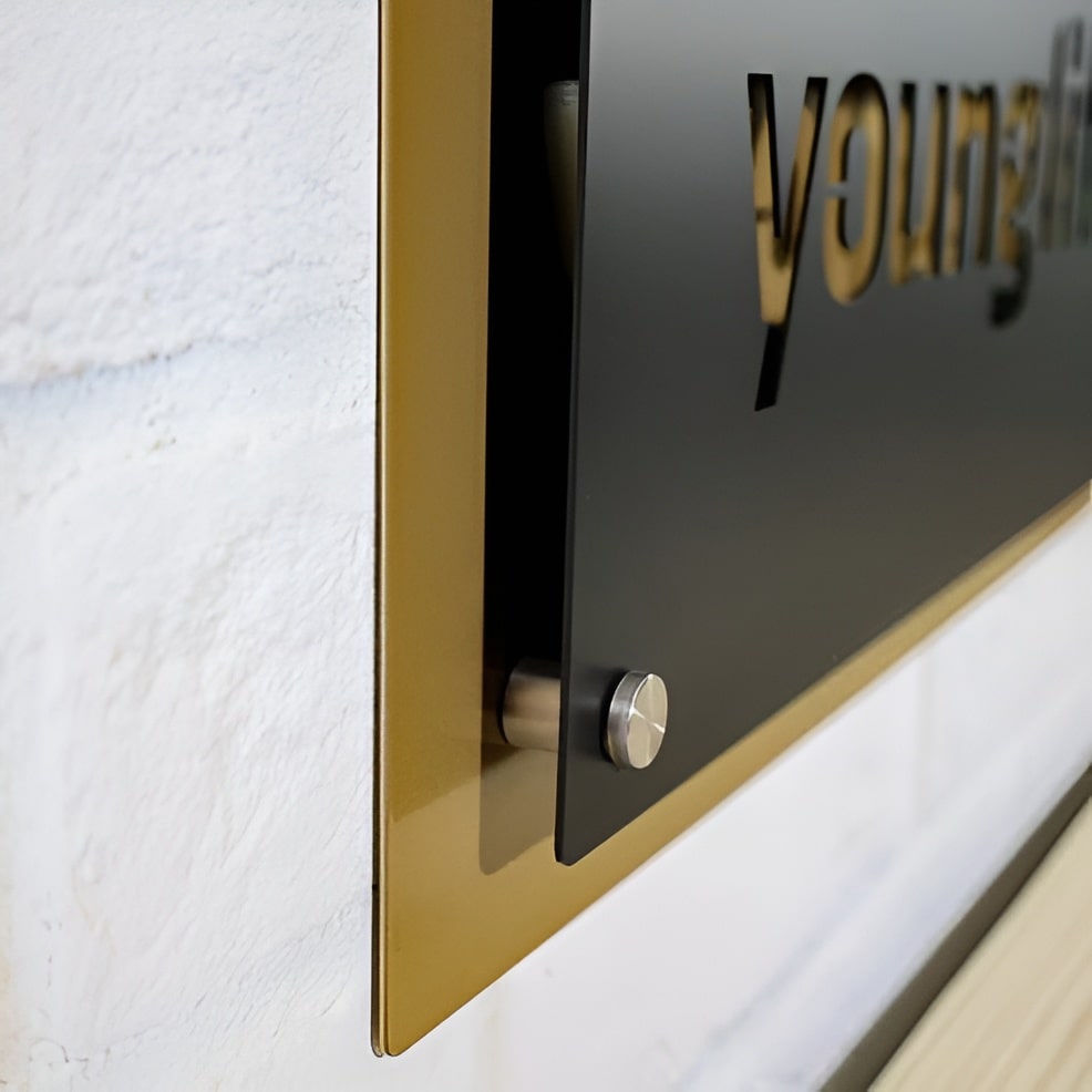 Close-up of a metallic frame featuring “Younglife” branding, displayed on a textured white surface, highlighting sleek metal craftsmanship and detailed design.