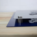 Close-up of a metallic mount with a blue base placed on a wooden surface, showcasing durable construction and design for secure installation.