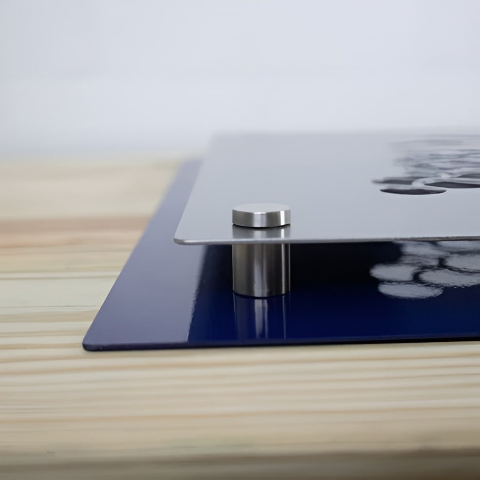 Close-up of a metallic mount with a blue base placed on a wooden surface, showcasing durable construction and design for secure installation.