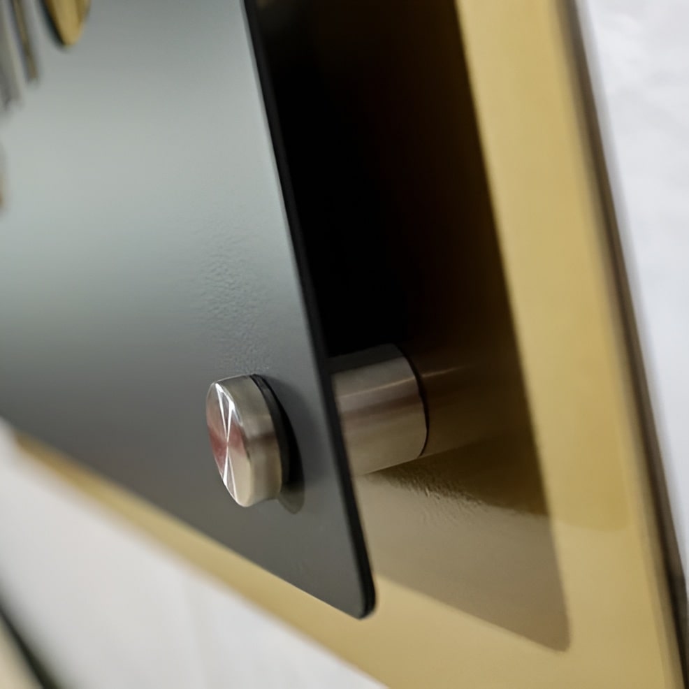 Close-up of a metal business logo mounted on a wall, showing the mounting details with a blurred background, highlighting durable construction and professional design.
