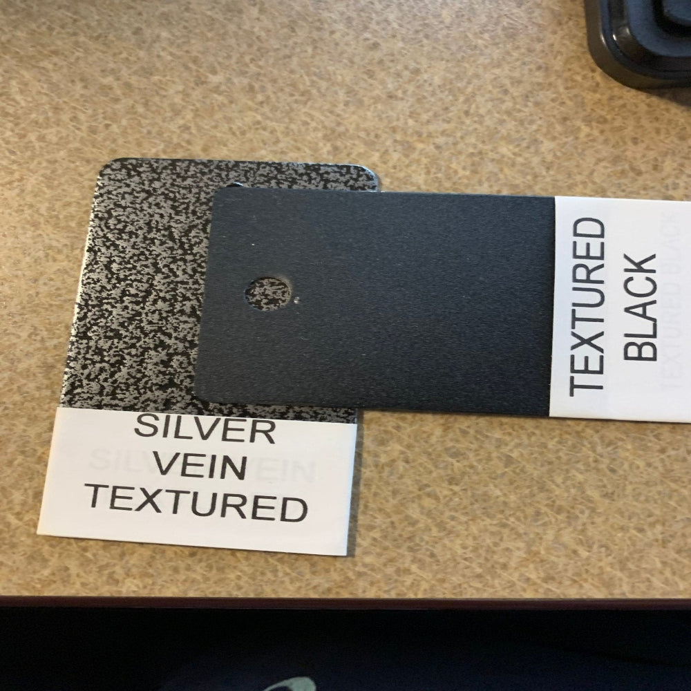 Textured black and silver vein leather metal color swatch samples displayed on beige surface, House Sensations Art branding, decorative material reference