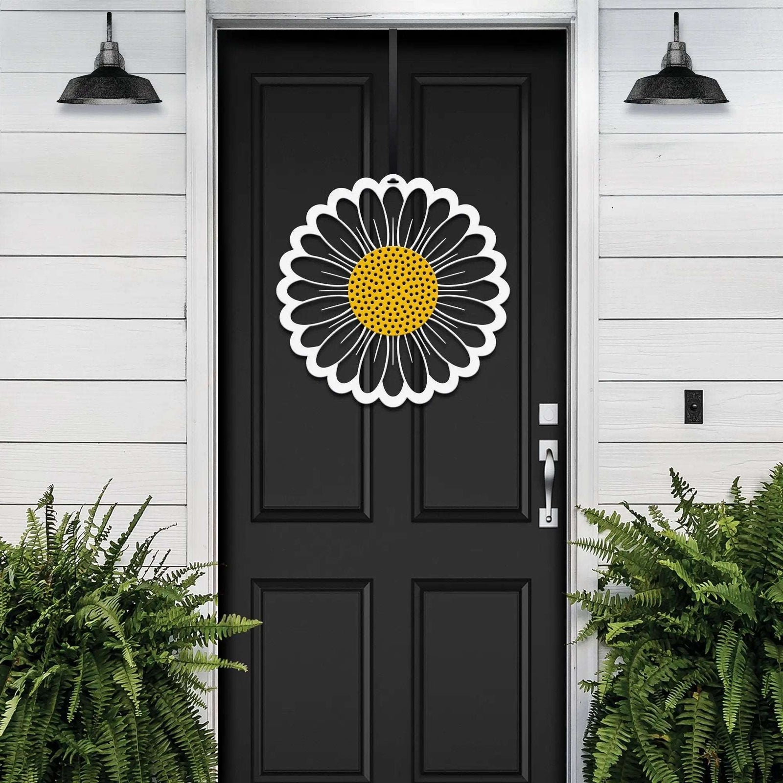 Black door with sunflower design metal sign or decal on white wooden wall, decorative outdoor home entrance accent