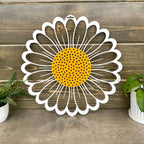 Decorative metal wall art of daisy with yellow center and white petals on wooden background, custom indoor or outdoor home décor accent