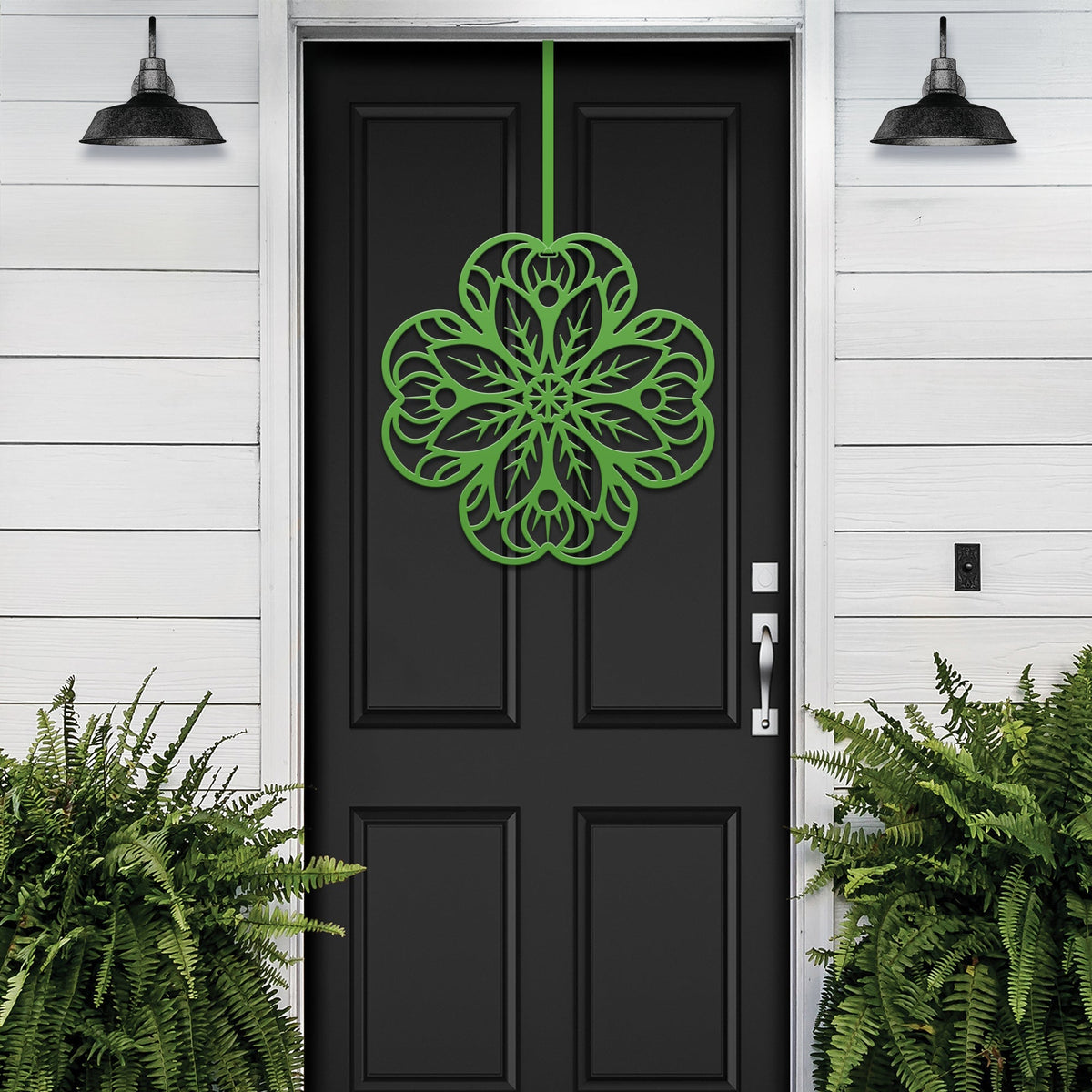 Black front door with light green floral mandala metal wall art, white exterior wall with green plants, custom powder coated farmhouse entry décor, elegant welcome sign design