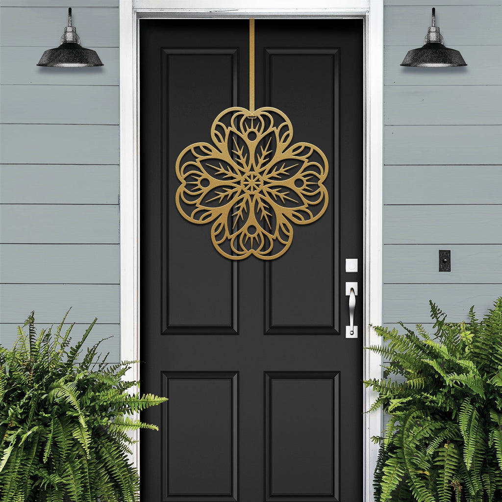 Black front door with gold floral mandala metal door hanger, light blue wall and green plants, custom powder coated farmhouse entry décor, elegant welcome sign design