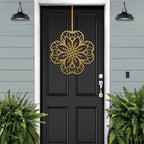 Black front door with gold floral mandala metal door hanger, light blue wall and green plants, custom powder coated farmhouse entry décor, elegant welcome sign design