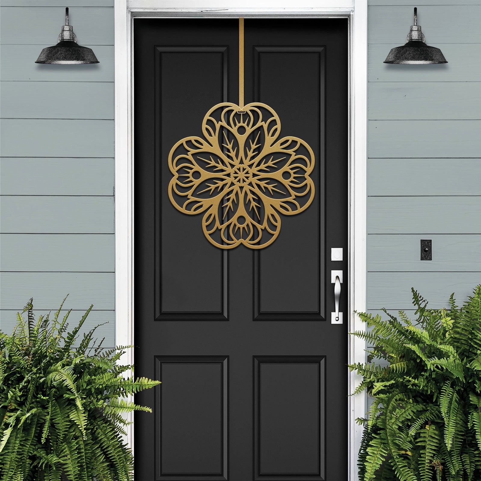 Black front door with gold floral mandala metal door hanger, light blue wall and green plants, custom powder coated farmhouse entry décor, elegant welcome sign design