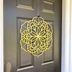 Yellow floral mandala metal wreath wall art on dark wooden door, side view, custom powder coated farmhouse entry décor, elegant front door welcome sign design