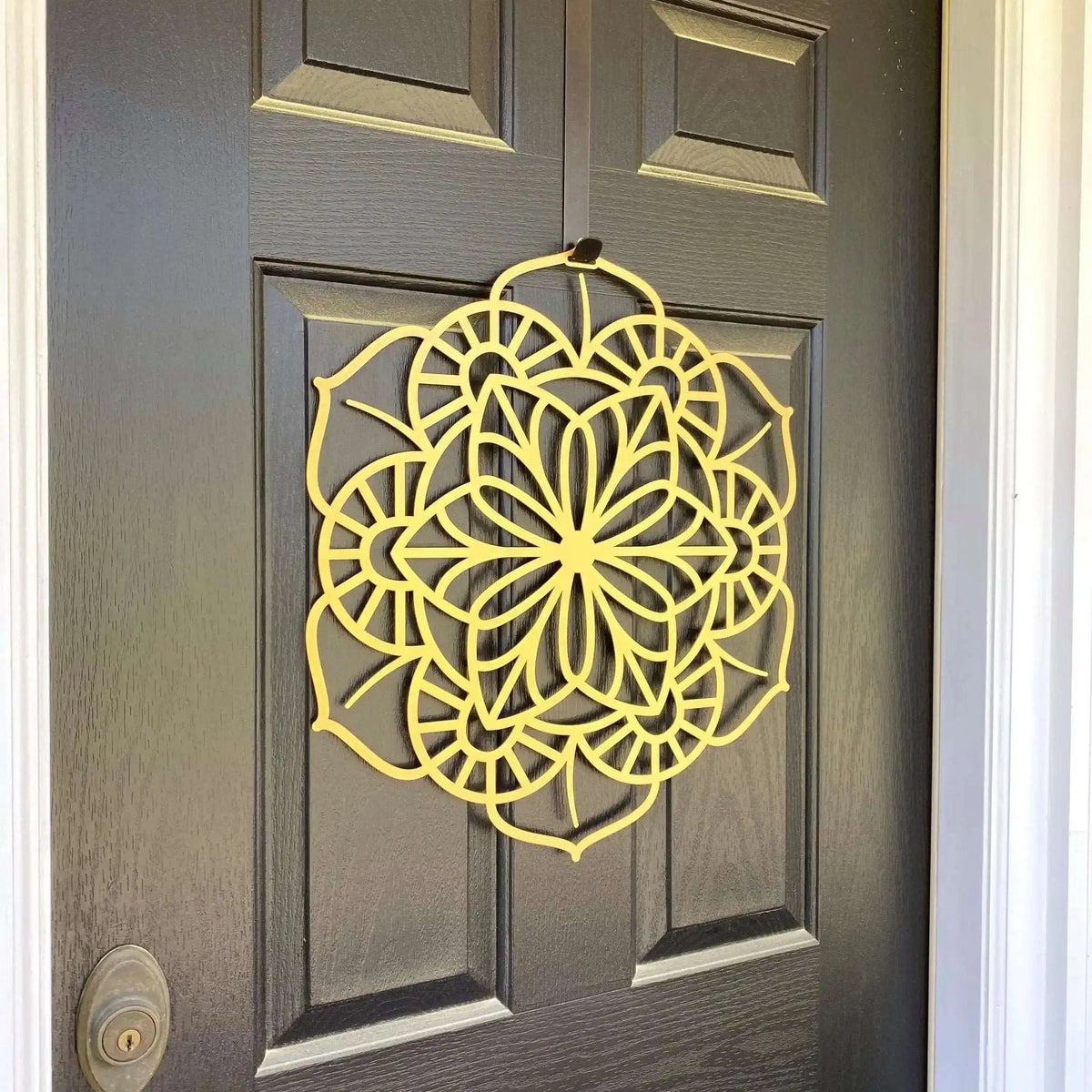 Yellow floral mandala metal wreath wall art on dark wooden door, side view, custom powder coated farmhouse entry décor, elegant front door welcome sign design