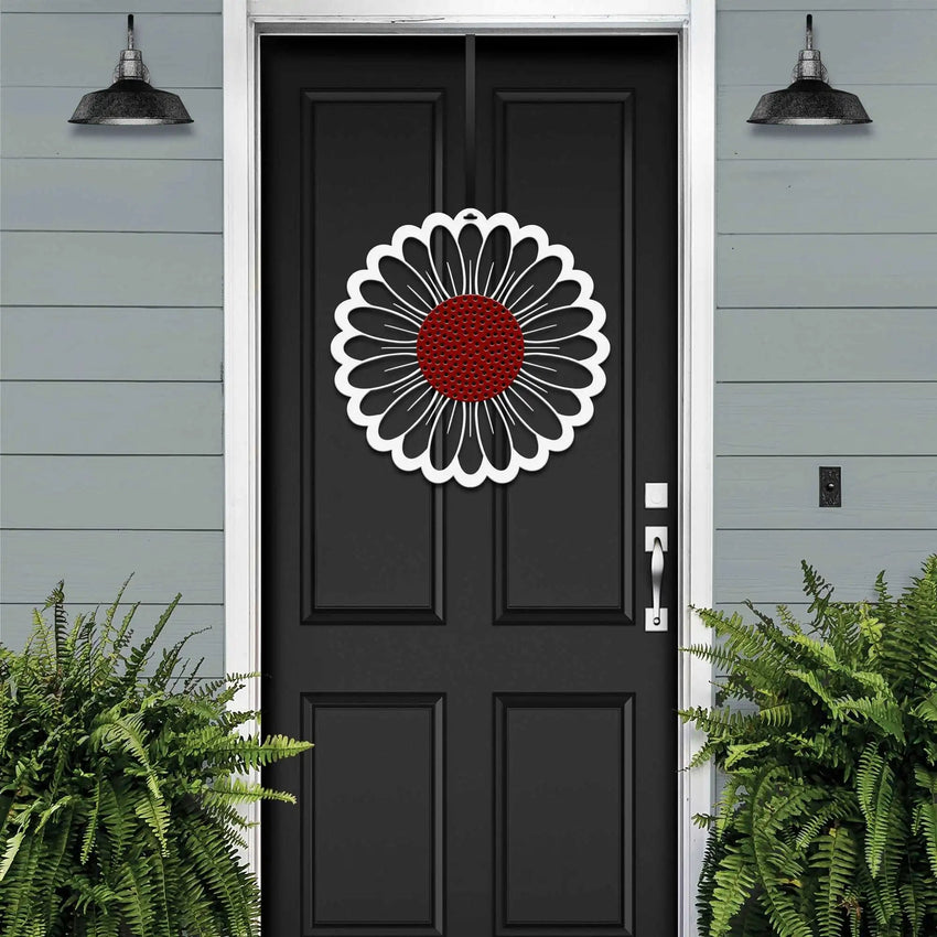 Black front door with circular floral wreath design, white and red metal accent décor, modern farmhouse entryway, curb appeal exterior home styling, custom metal wall art inspiration