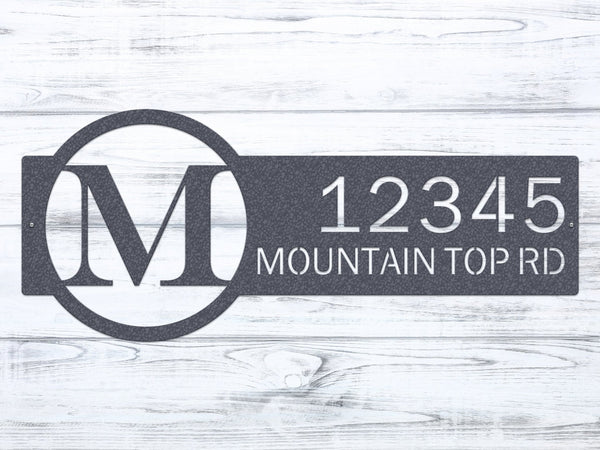 Close-up oil rubbed bronze monogram sign with letter 'M' and '12345 Mountain Top RD'.