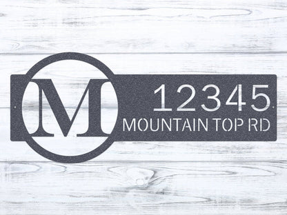 Close-up oil rubbed bronze monogram sign with letter 'M' and '12345 Mountain Top RD'.