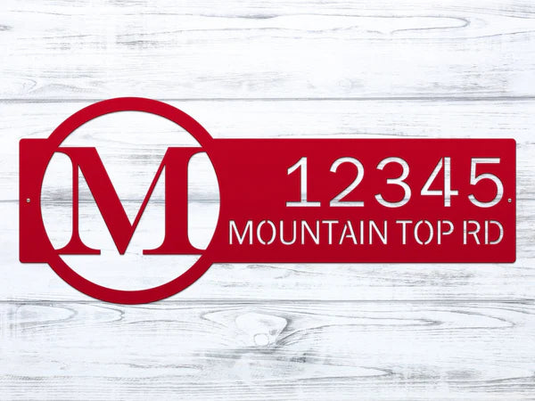Close-up deep red metal monogram sign with letter 'M' and '12345 Mountain Top RD'.