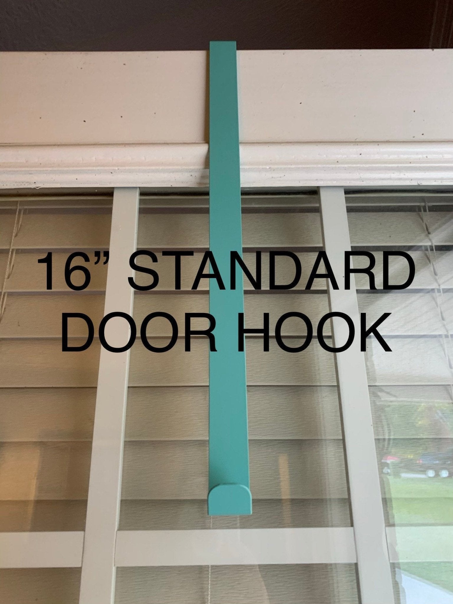 HouseSensationsArt metal over-the-door wreath hook in teal, 16-inch standard size, displayed on glass door, part of 90-color USA-made collection.