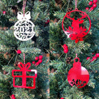 Four Christmas tree ornaments shaped like a ball, deer, gift, and bell hanging on a decorated tree, festive holiday decorations for seasonal home décor