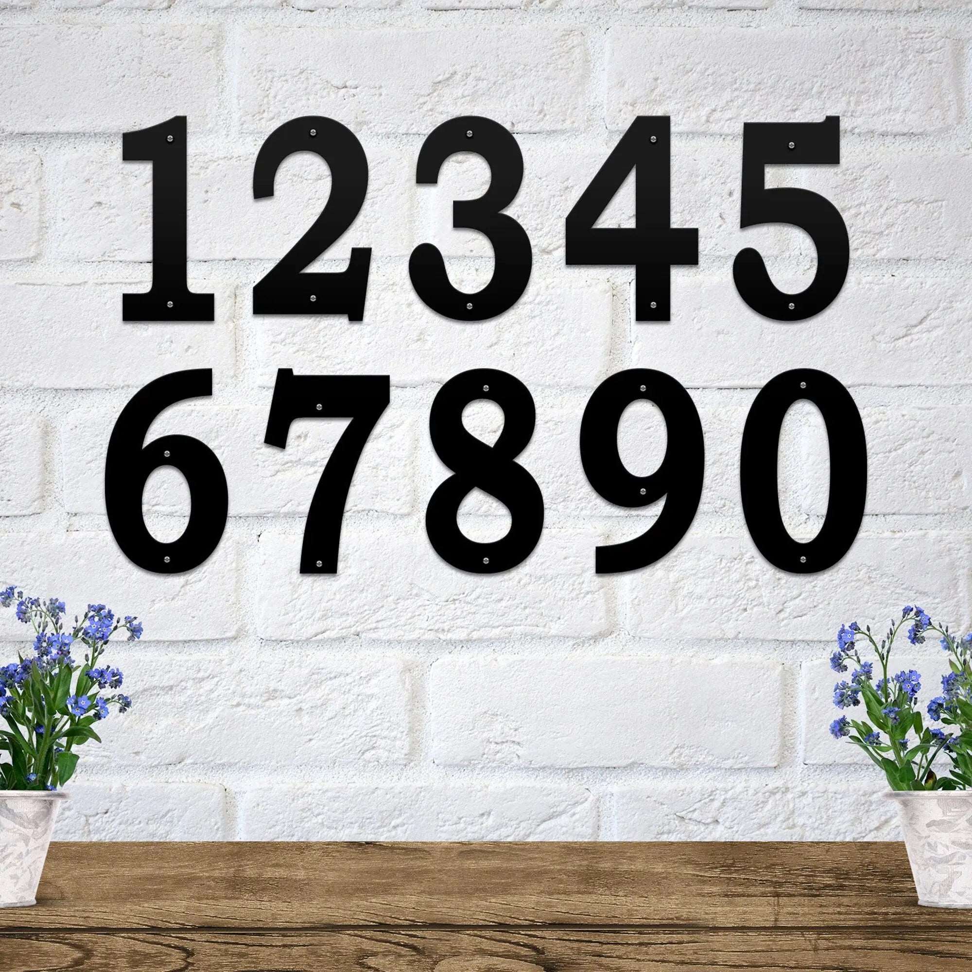 Set of black metal house numbers mounted on a white brick wall for custom address signs, personalized home exterior décor, and decorative outdoor metal signage