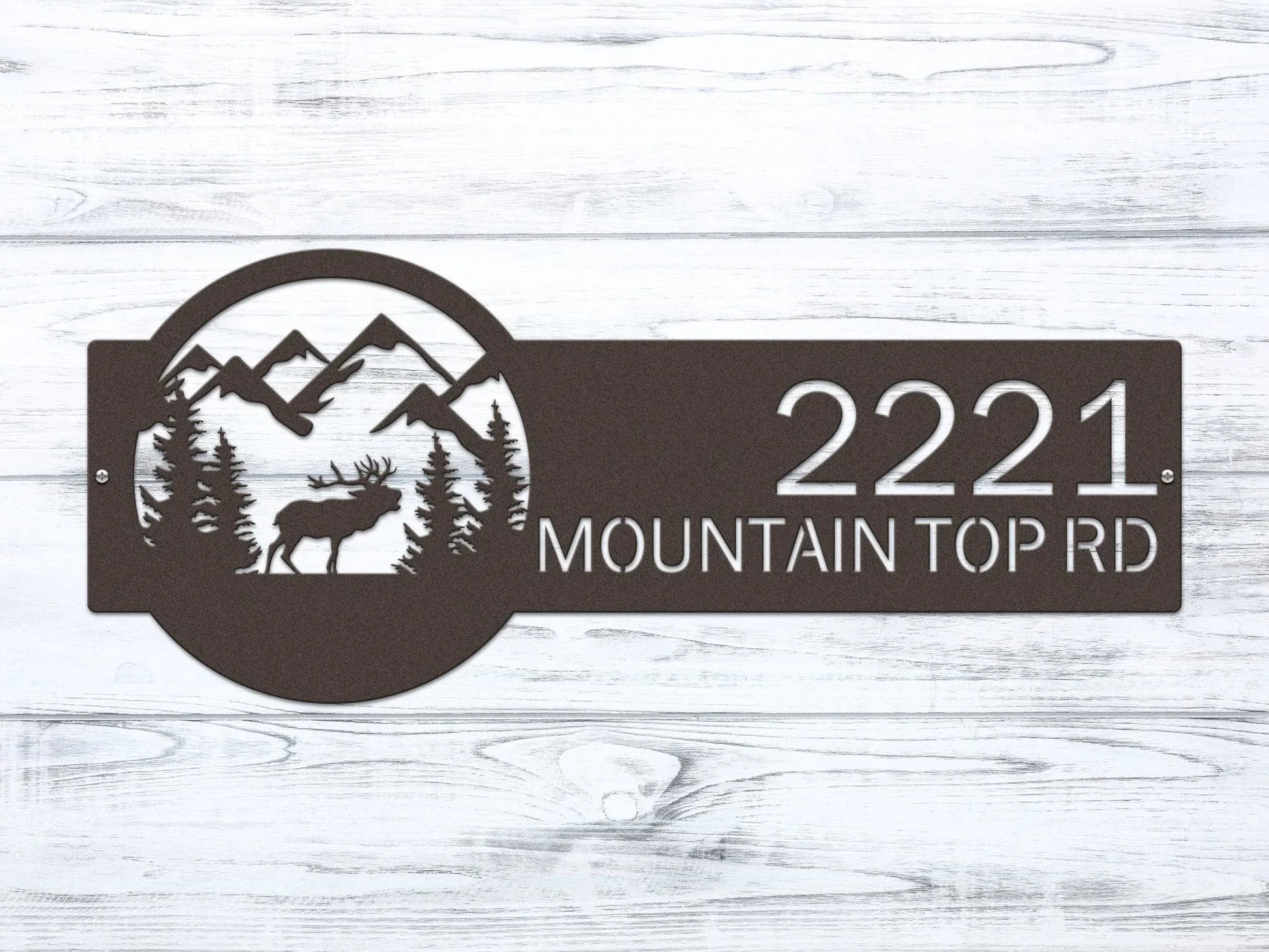 Oil-rubbed bronze Mountain Elk Address Sign featuring elk, pine trees, and mountain on the right, with house number '2221 Mountain Top Rd' on the left, mounted on the door wall.
