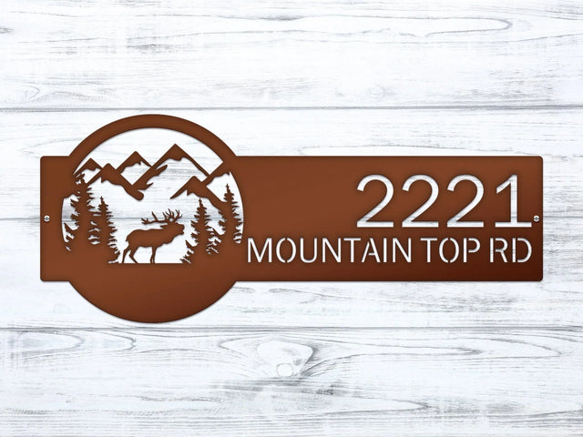 Close-up of Candy copper Mountain Elk Address Sign featuring elk, pine trees, and mountain on the right, with house number '2221 Mountain Top Rd' on the left.
