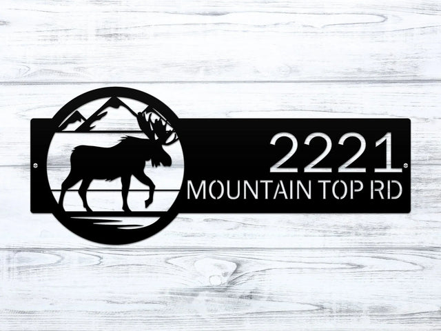 Close-up of black Mountain Moose Address Sign with moose and mountain on right and house number '2221 Mountain Top Rd'.