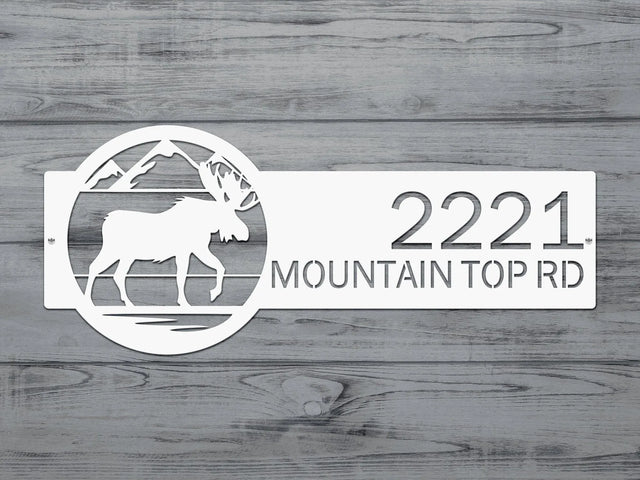 Close-up of white Mountain Moose Address Sign with moose and mountain on right and house number '2221 Mountain Top Rd'.