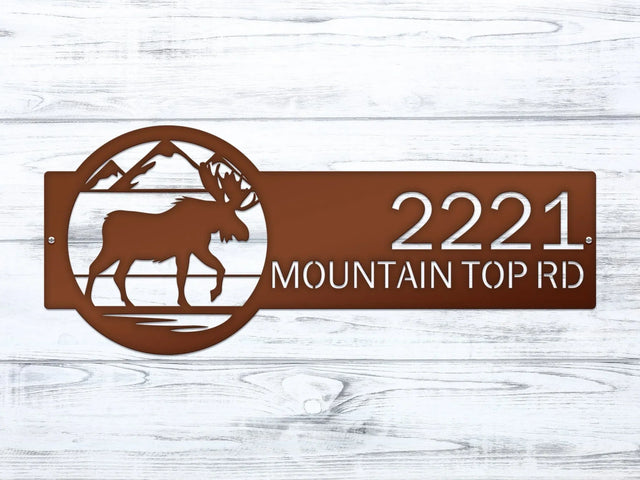 Close-up of candy copper Mountain Moose Address Sign with moose and mountain on right and house number '2221 Mountain Top Rd'.