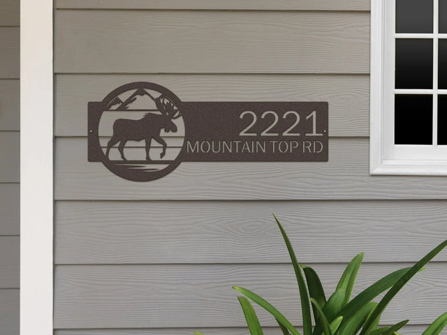 Oil rubbed bronze Mountain Moose Address Sign with moose and mountain on right and '2221 Mountain Top Rd', mounted on the door wall.