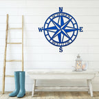 Blue nautical compass rose metal wall décor on white wall with wooden ladder and table in foreground, coastal-inspired décor, HouseSensationsArt