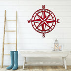 Red nautical compass rose metal wall décor on white wall with wooden ladder and table in foreground, coastal-inspired décor, HouseSensationsArt